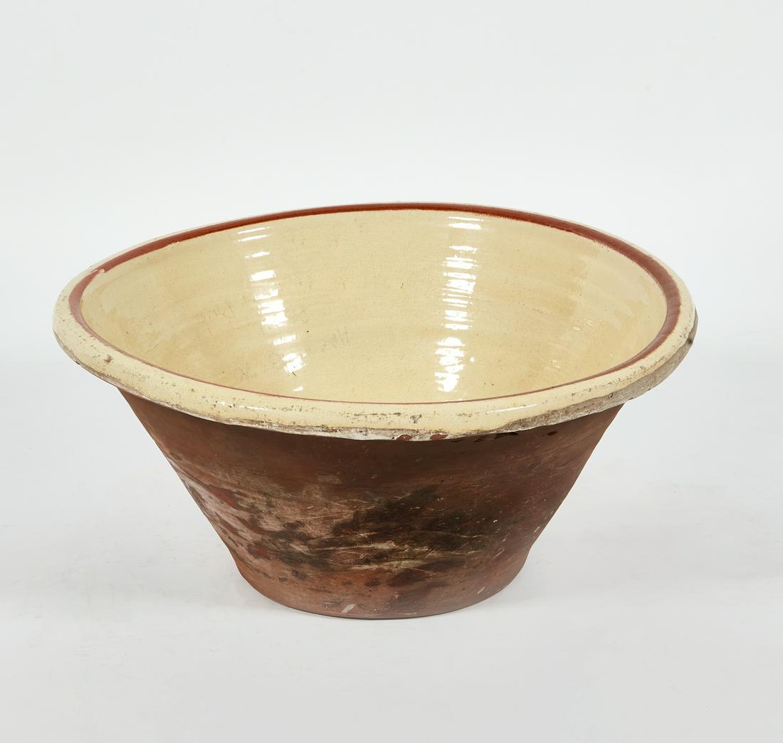 A large pale yellow and brown glazed pottery bowl (1 of 2)