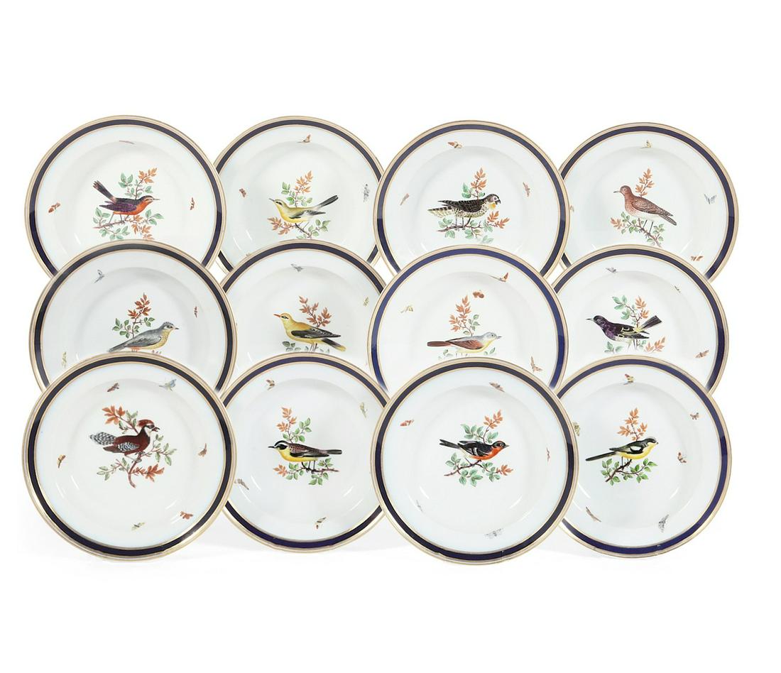 Twelve Meissen porcelain soup bowls: A set of twelve Meissen porcelain soup bowls 19th century Decorated with birds perched on branches and butterflies within gilt and cobalt borders; underglaze blue crossed swords, some above the number