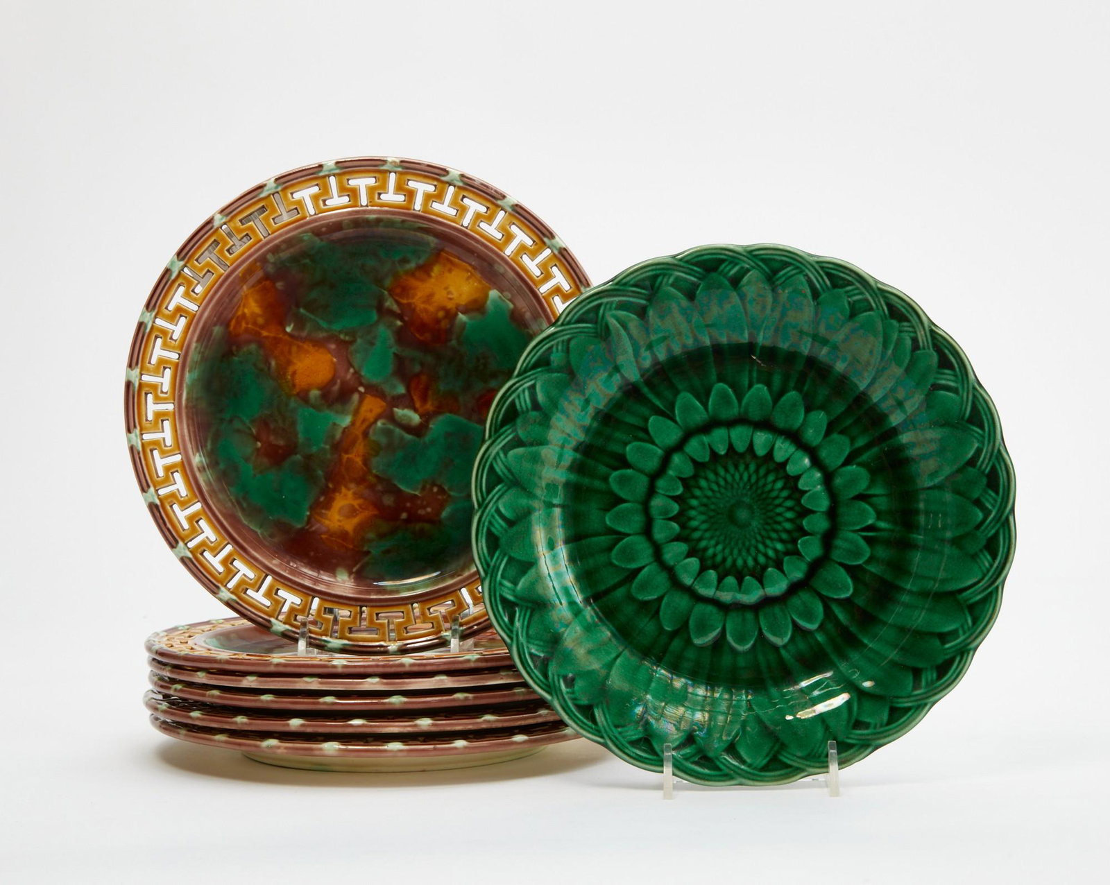 A group of seven Wedgwood majolica plates: A group of seven Wedgwood majolica plates late 19th century Comprising a set of six with mottled centers and reticulated Greek key borders, impressed WEDGWOOD and NOX, some impressed S, diameter 8 5/8