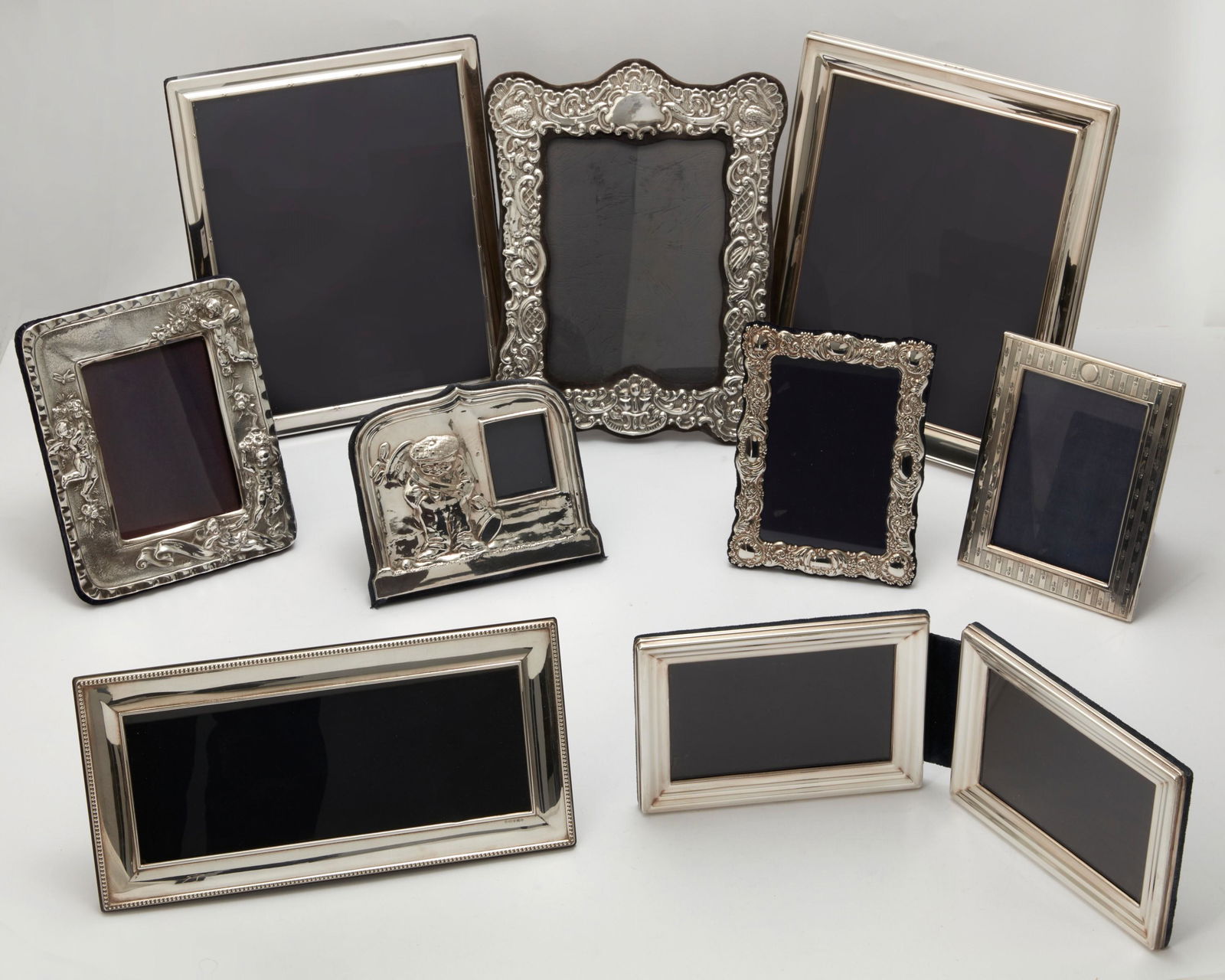 Nine sterling silver table top photo frames: A group of nine sterling silver table top photograph framesthe largest 12 x 10in (30.5 x 25.5cm)