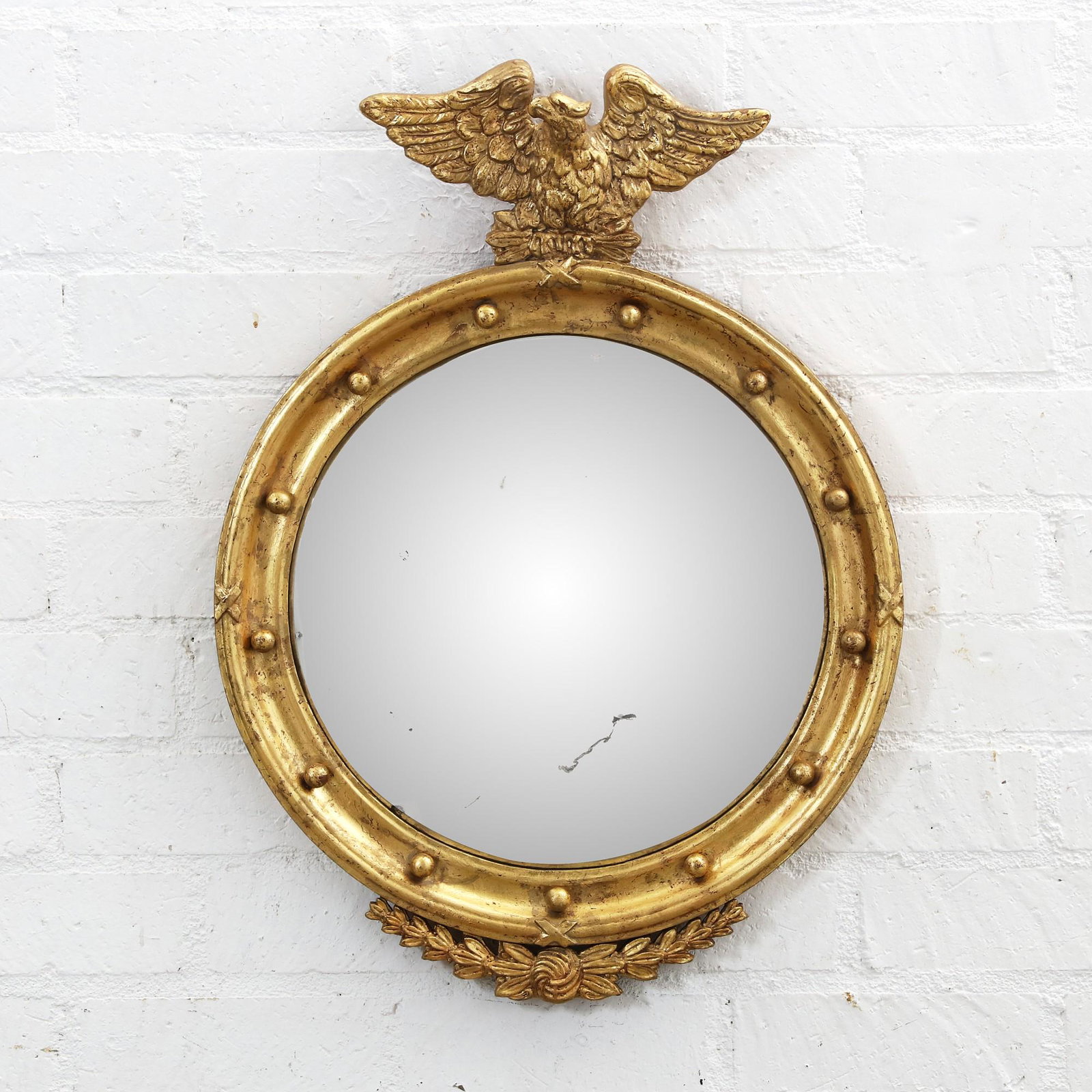 A Regency style giltwood and convex mirror: A Regency style giltwood and convex mirror20th centuryheight 29in (73.5cm); diameter of plate 17 1/2in (44.5cm)