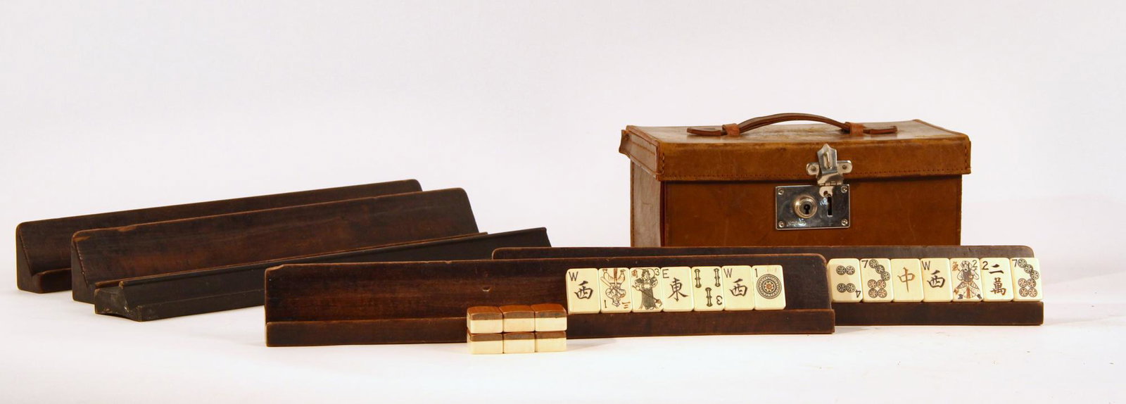 A Mahjong set in a leather traveling case: A Mahjong set in a leather traveling case With five wooden tile stands. height 4 1/2in (11.5cm); width 9in (23cm); depth 5 1/2in (14cm) Provenance: Property from the Estate of Ray and Ruth Hill, Seatt