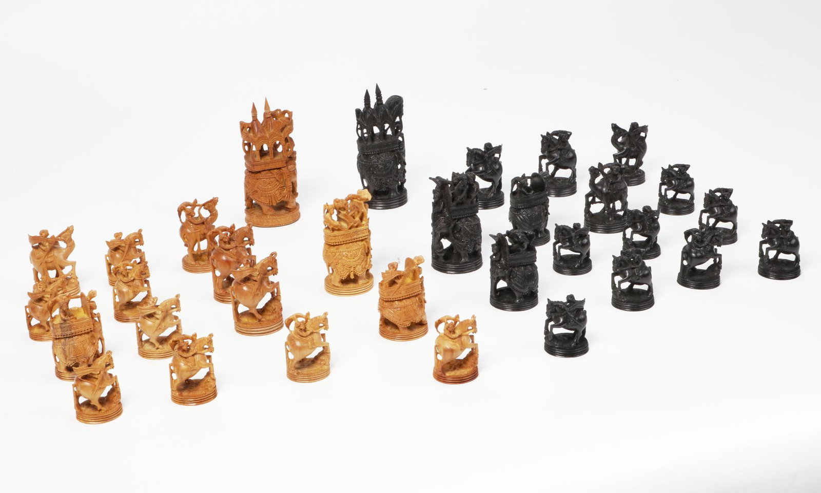 A Southeast Asian ebony and sandalwood chess set: A Southeast Asian ebony and sandalwood chess setIn a fitted box.height of tallest piece 6in (15cm); box height 3 1/4in (8cm); width 22 3/4in (58cm); depth 13 1/4in (33.5cm)