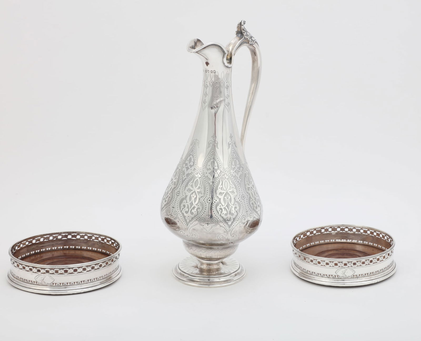 Victorian silver jug and pair George III coasters: A Victorian sterling silver claret jug and a pair of George III sterling silver and mahogany bottle coastersthe jug Thomas Smily, London1876The coasters no maker's mark evident, London, 1790, engraved