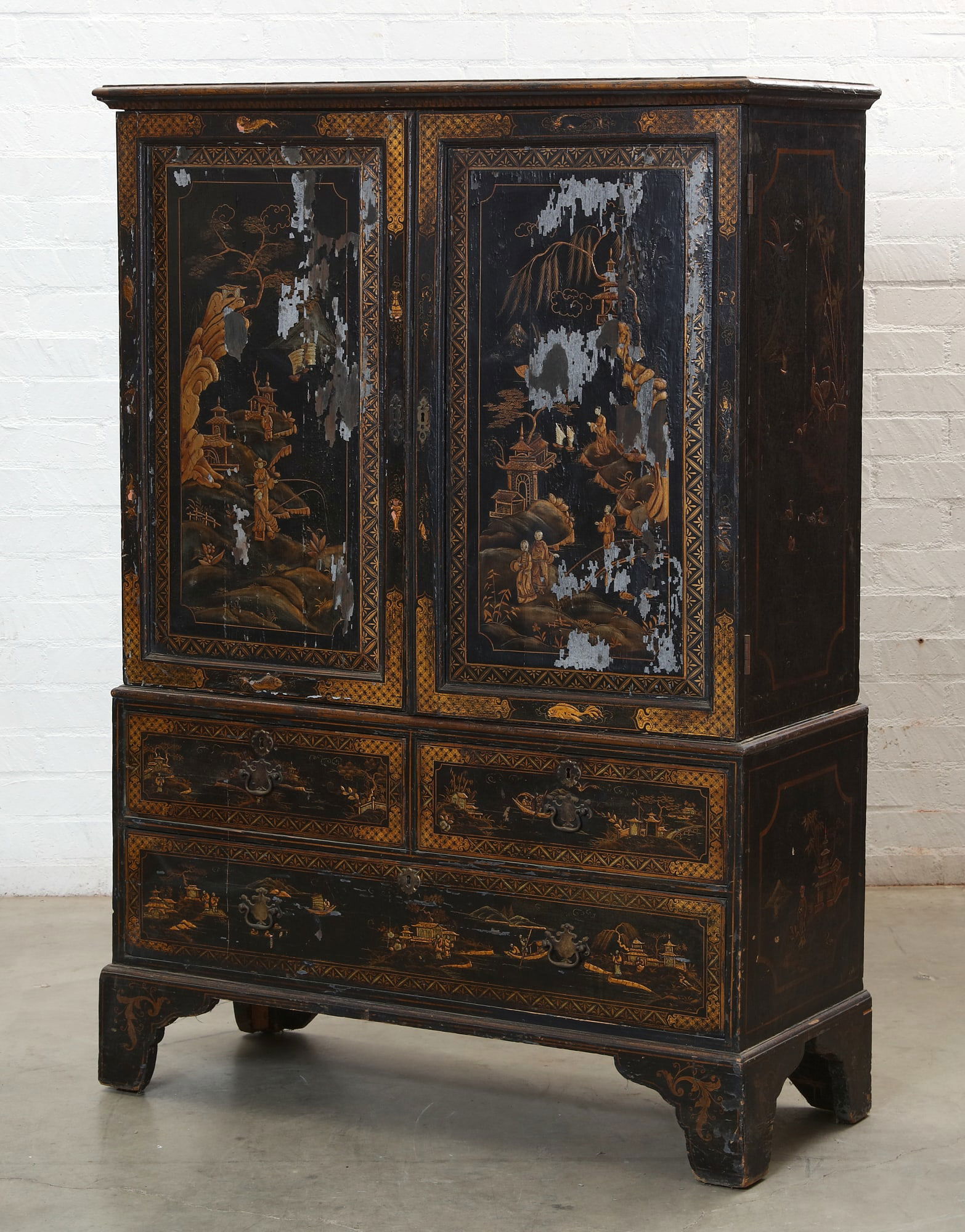 A George III black and gilt japanned linen press: A George III black and gilt japanned Chinoiserie decorated linen presslate 18th centuryThe upper section with a pair of doors enclosing four linen slides.height 70in (178cm); width 49in (125cm); depth