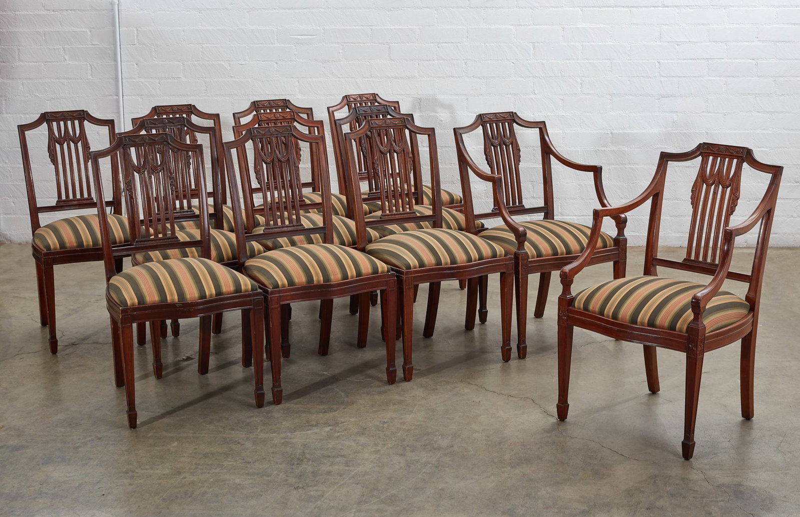 Twelve George III style mahogany dining chairs: A set of twelve George III style mahogany dining chairs early 20th century Comprising two armchairs and ten side chairs. (12) the armchairs height 37in (94cm); width 22in (56cm); depth of seat 19in (4