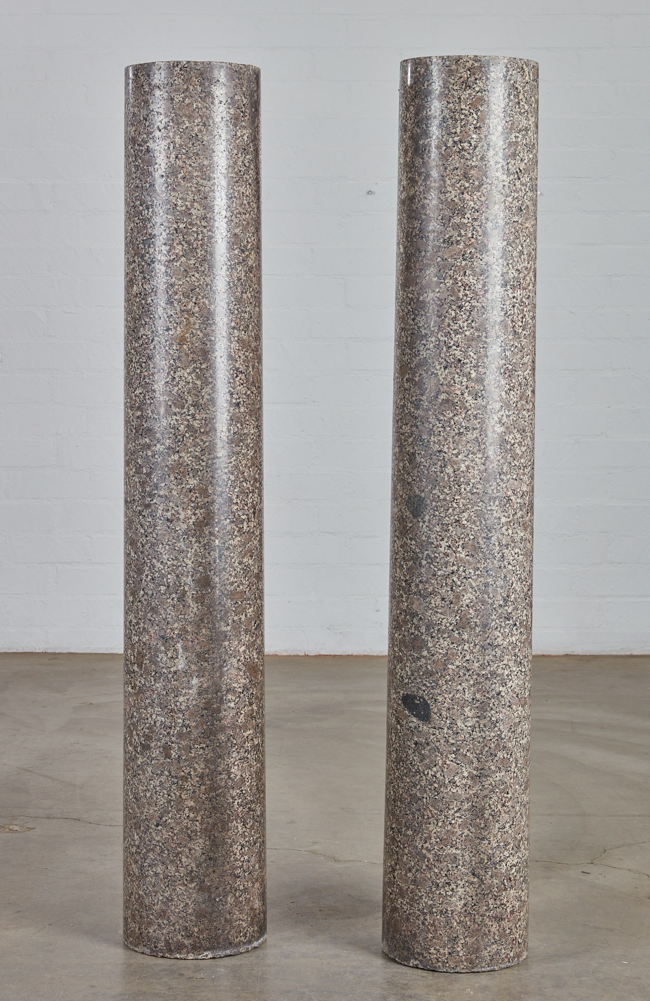 A pair of granite columns: A pair of granite columnslate 19th/20th centuryheight 56 3/4in (144cm); diameter 8 1/2in (22cm)