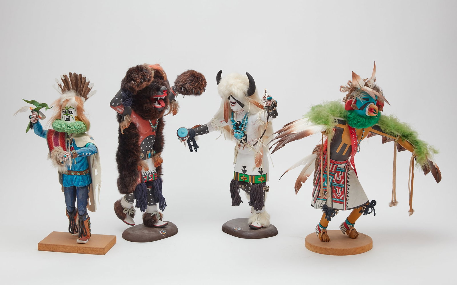 A group of four Native American katchinas: A group of four Native American polychrome decorated wood katchinas various makers modern Two variously signed. the largest height 20 1/2in (52cm); width 24in (61cm); depth 12in (31cm) Provenance: T