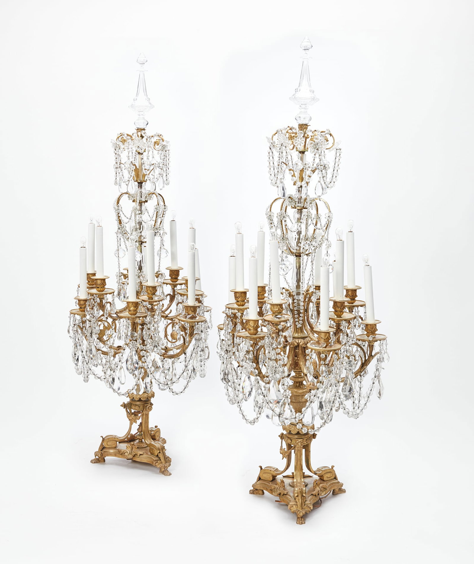 A pair of Louis XVI style twelve light candelabra: An imposing pair of Louis XVI style gilt bronze and cut glass twelve light candelabra late 19th century height 50in (127cm); diameter 16in (41cm) Provenance: The Edmund W. and Carol Browning Dumke Fam