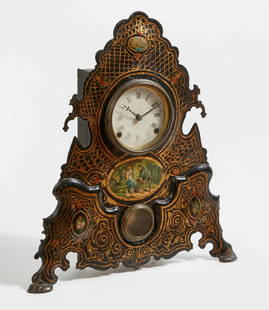 A Continental mantel clock: A Continental parcel gilt, ebonized and polychrome decorated mantel clock mid 19th century The circular painted dial with Roman chapters, with twin train movement, with remants of old labels to