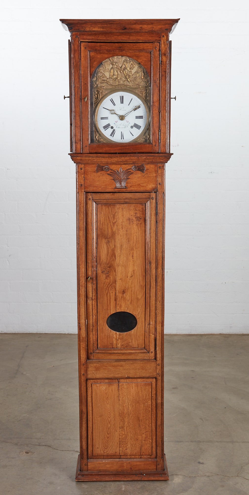 A French Provincial carved oak regulateur: A French Provincial fruitwood regulateur late 18th/early 19th century height 89in (226cm); width 21in (53cm); depth 11/12in (29cm)