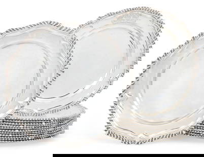Twelve George III sterling silver dinner plates: A set of twelve George III sterling silver dinner platesAndrew Fogelberg & Stephen Gilbert, London1781With coat of arms surmounted by a coronet above a motto Excitari Non Hebescere; together with a Vi