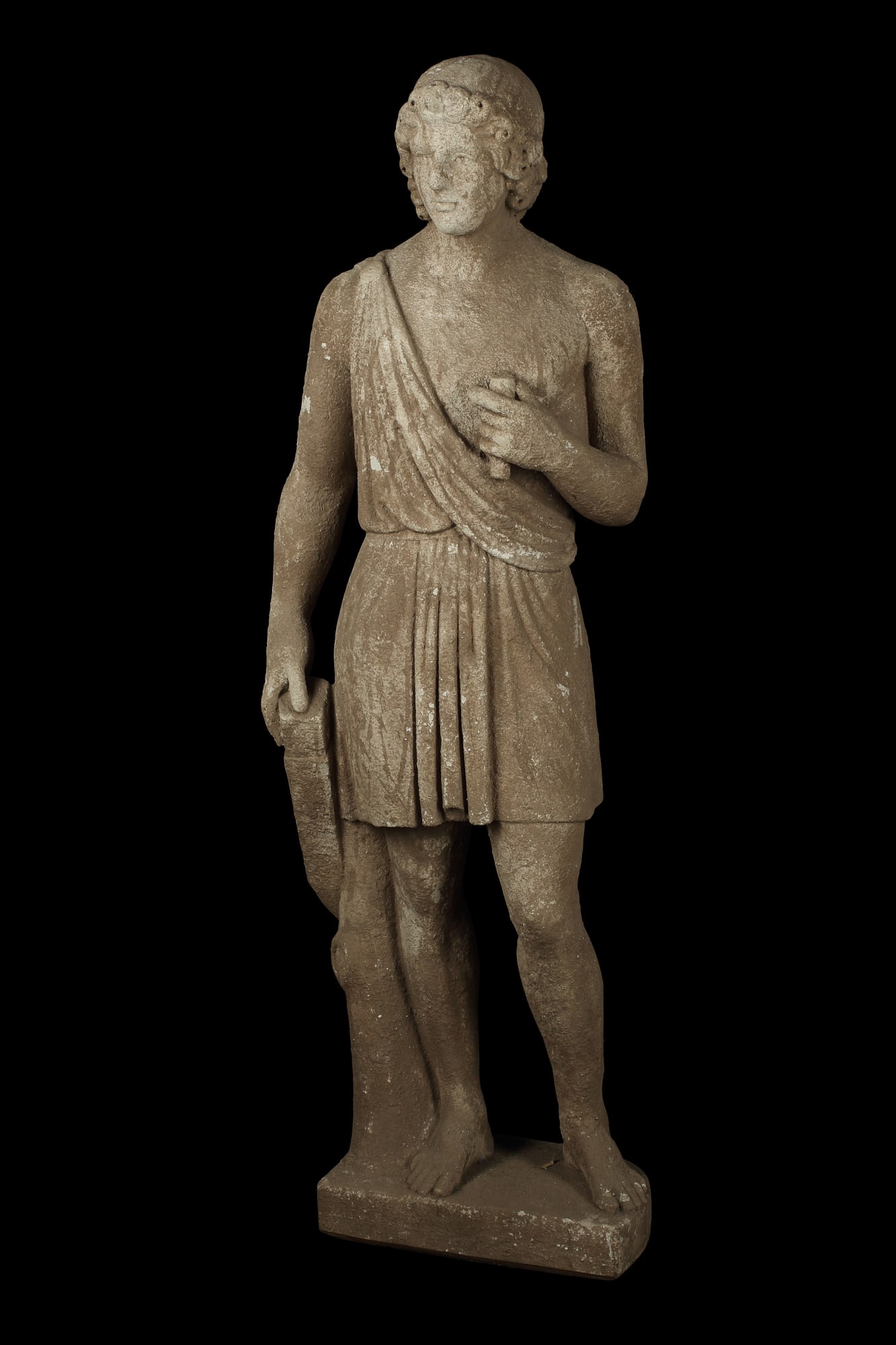 A Continental limestone figure of a youth: A Continental tinted carved limestone figure of a classical youth19th/20th centuryheight 51 1/2in (131cm); width 16 1/2in (42cm); depth 11in (28cm)