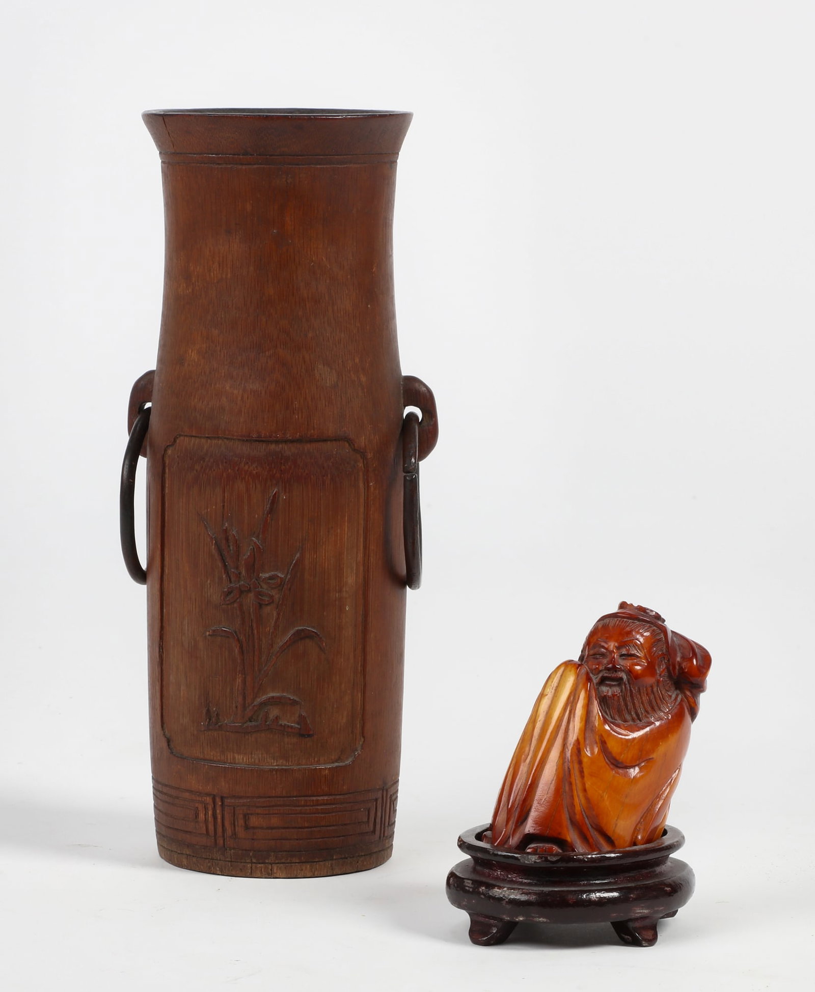 A Japanese Netsuke with a carved bamboo brush pot: A Japanese Netsuke carved bone model of a seated scholar with carved characters to underside and on wood stand together with a carved bamboo brush pot. (2) height 2 3/4in (7cm); width 3in (7.5cm); dep