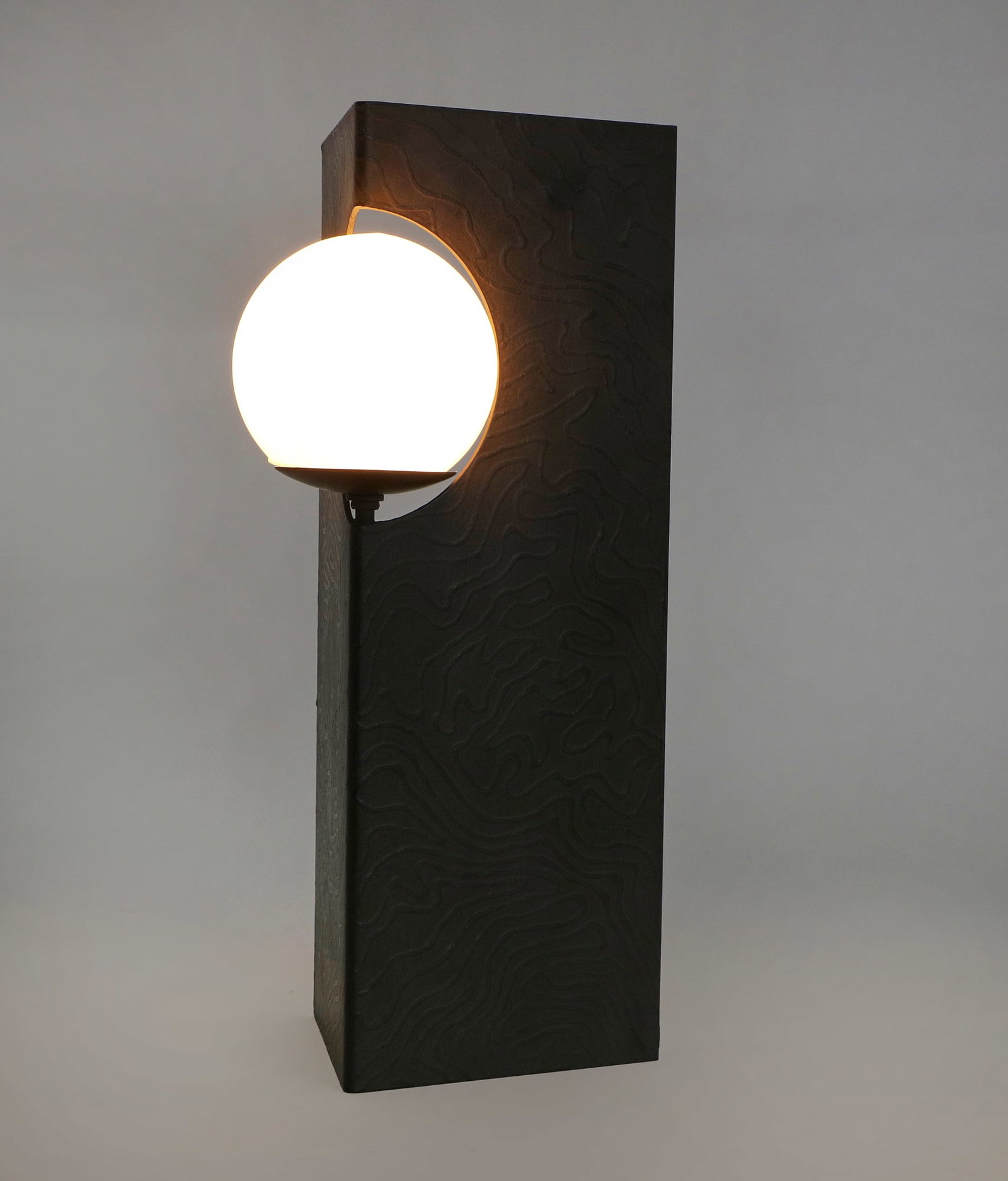A Paul Marra black steel Solitaire table lamp: A Paul Marra textured black steel Solitaire table lamp contemporary With white glass shade. height 19in (48.5cm); width 8in (20.5cm); depth 5 1/2in (14cm)