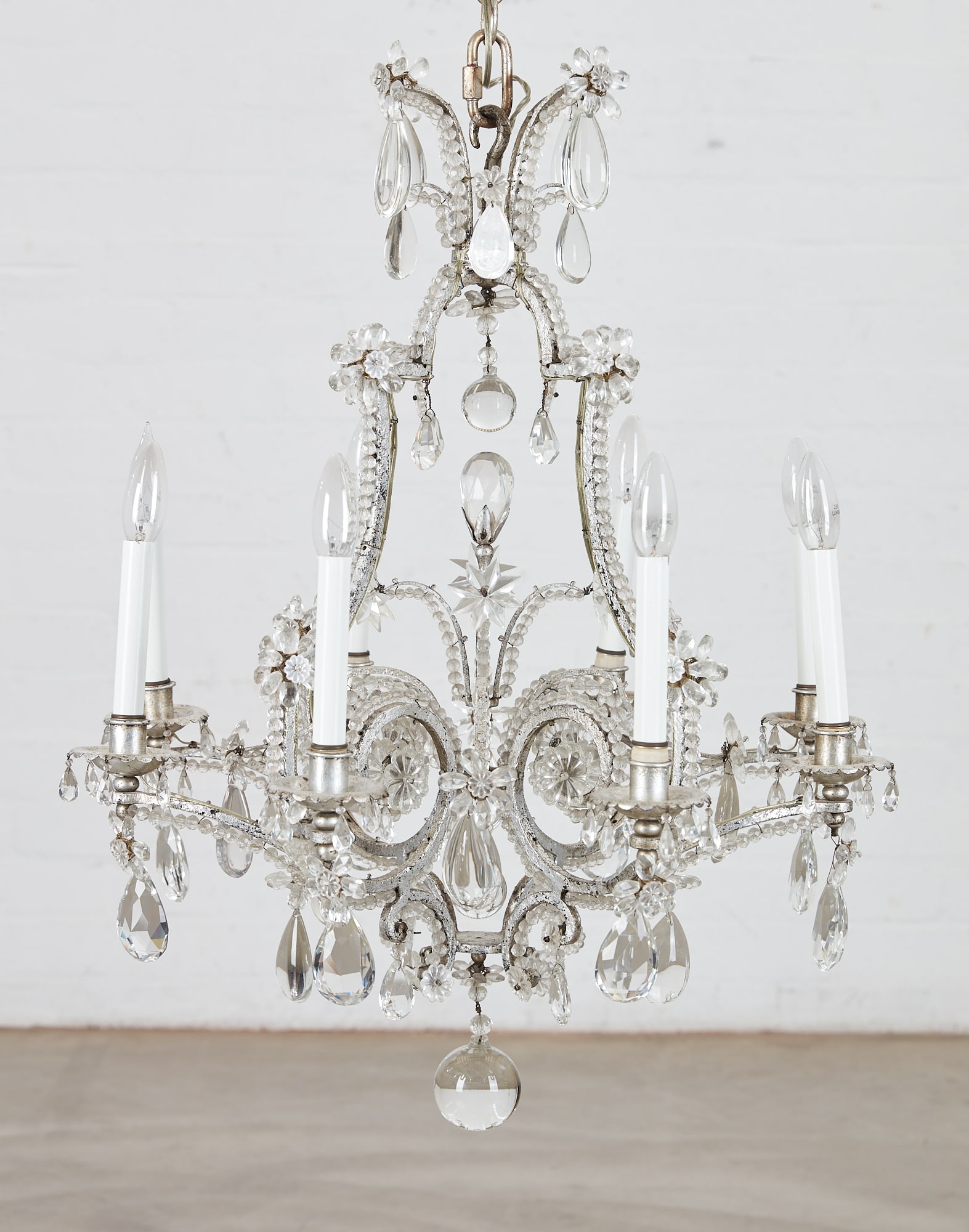 A Rococo style glass eight light chandelier: A Rococo style silvered metal and molded clear glass eight light chandelier possibly Dennis & Leen modern height 32in (80cm); diameter 25in (62.5cm)
