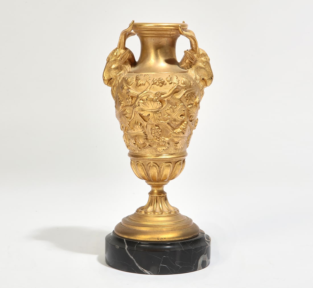 A French gilt bronze and marble urn: A French gilt bronze and marble urn late 19th/early 20th century With ram's head handles to either side. height 9 1/2in (24cm); diameter 4 1/4in (10.5cm) Provenance: Property from a Private Collection