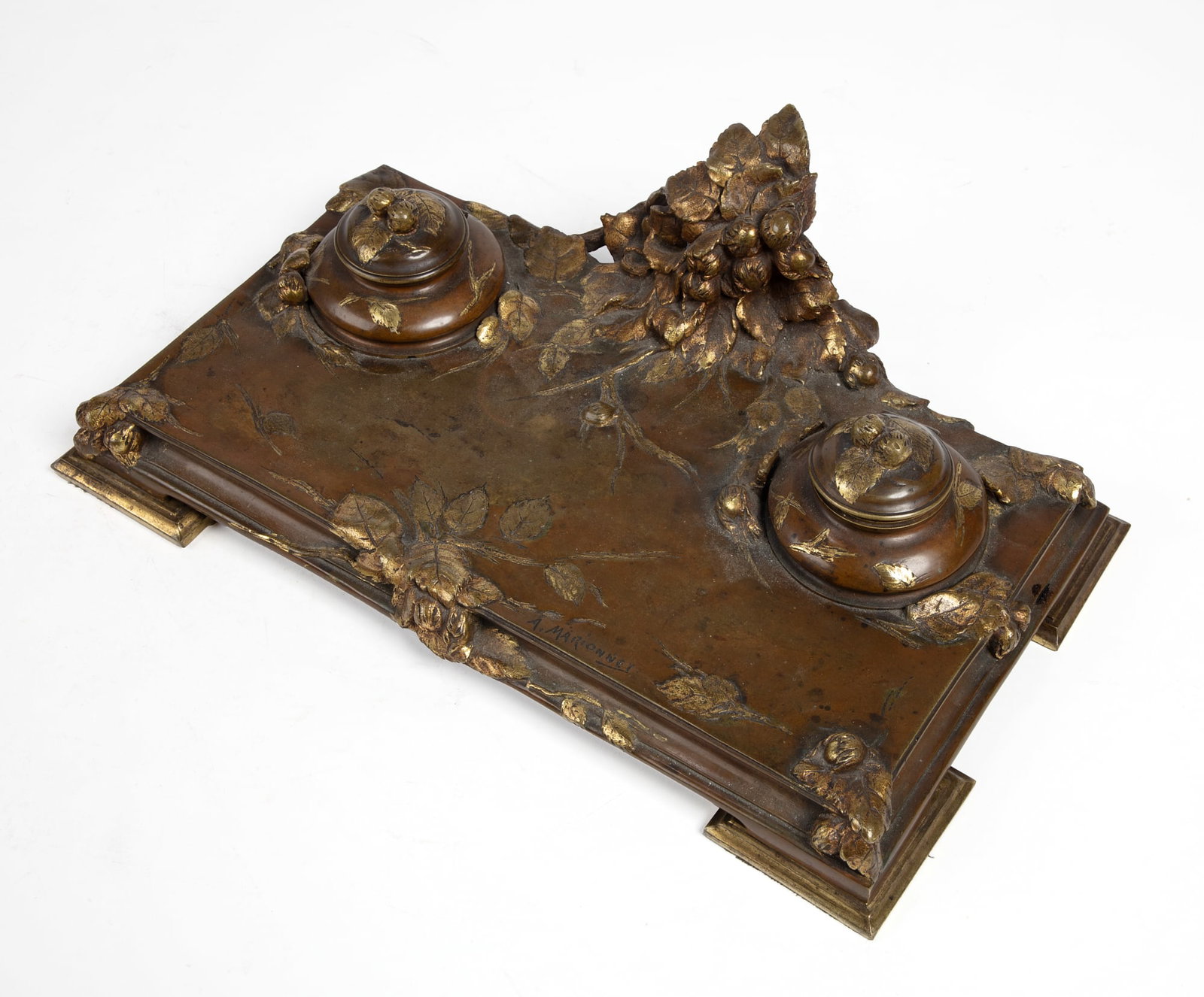 A French Art Nouveau bronze encrier: A French Art Nouveau parcel gilt and patinated bronze encrier Albert Marionnet early 20th century inscribed A. MARIONNET. height 4 1/2in (11cm); width 14 1/2in (37cm); depth 8in (20cm)