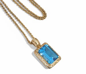 A blue topaz and gold pendant on chain