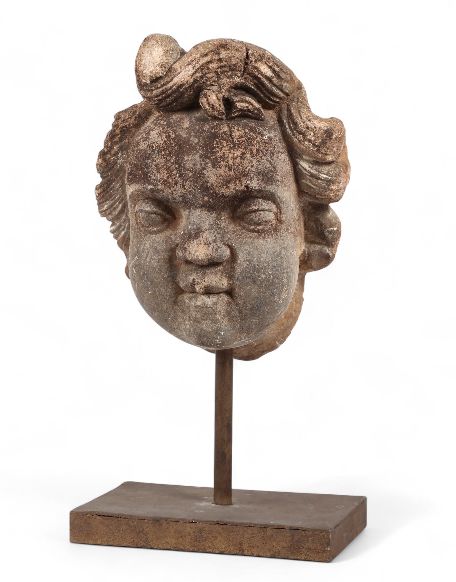 An Italian stone head of a putto: An Italian stone head of a putto On stand. overall height 17 1/4in (44cm); width 9in (23cm); depth 6 1/2in (16.5cm)