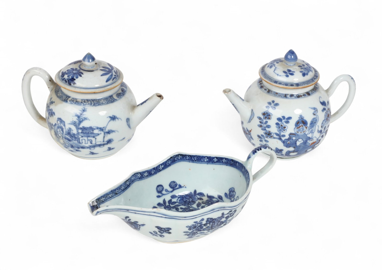 Three Chinese Export blue and white porcelain tablewares: Three Chinese Export blue and white porcelain tablewares Comprising two teapots and a sauceboat. teapots height 5 1/2in (14cm); width 7in (17.5cm); depth 4in (10cm) Provenance: Property from a Private