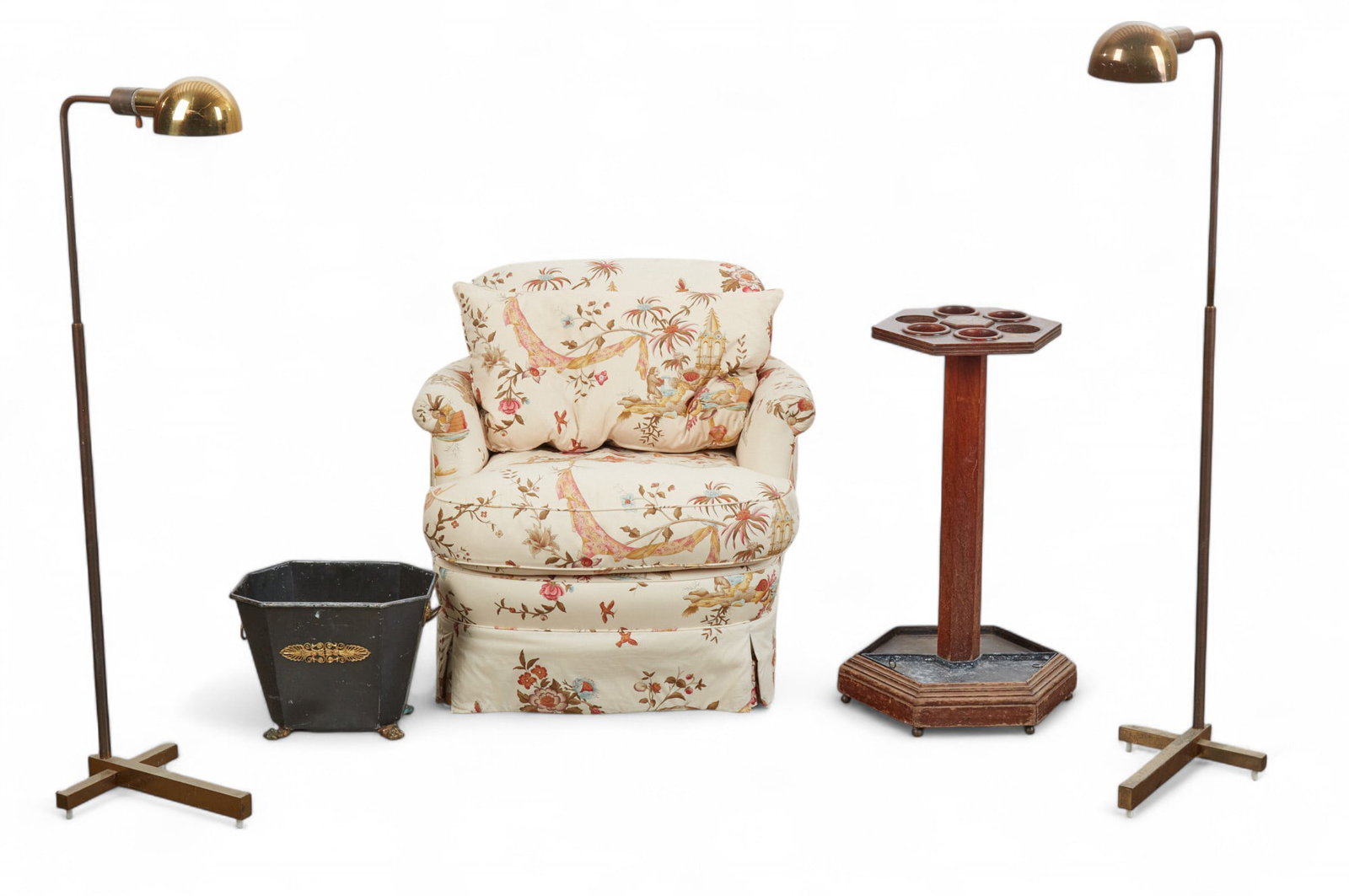A group of sitting room furnishings: A group of sitting room furnishings Comprising a fully upholstered lounge chair, a pair of telescopic brass floor reading lamps, a stained wood umbrella stand, and a gilt metal mounted tole waste bin.