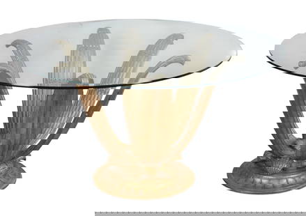 A circular glass table with carved giltwood base: A circular glass table with carved giltwood baseThe pedestal base cast as stylized leaves radiating from a central rosette, with scrolled and reeded decoration, supporting a circular glass top, on cir