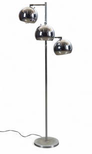 A mid-century modern chrome-plated three-light floor lamp, in the style of Robert Sonneman: A mid-century modern chrome-plated three-light floor lamp, in the style of Robert SonnemanWith three spherical shades on a vertical standard and circular weighted base.height 58 1/2in (149cm)