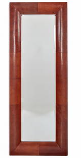 A  mid-century style  stitched leather mirror: A mid-century style stitched leather mirrorOf rectangular form, the beveled mirror plate within a wide frame wrapped in stitched reddish-brown leather, showing age-appropriate bowing to the mirror gla