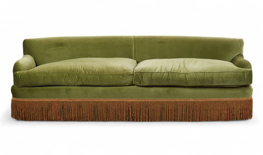 A custom-made green velvet curved sofa with fringe trim: A custom-made green velvet curved sofa with fringe trimUpholstered in green velvet with a curved back, loose seat cushions, and bullion fringe along the base, in there manner of Hollywood Regency30 x