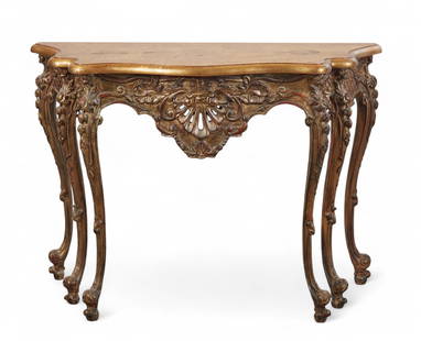 An giltwood Rococo Revival console table: An giltwood Rococo Revival console tableWith shaped top above a carved and pierced apron, raised on cabriole legs with scroll feet.height 31 in. (78.7 cm); width 42 in. (106.7 cm); depth 14 in. (35.6