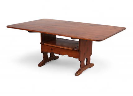 A Colonial Revival pine convertible trestle table/settle, 20th century: A Colonial Revival pine convertible trestle table/settle, 20th centuryThe rectangular plank top with hinged back rail converting to form a settle, above twin trestle supports joined by a medial stretc