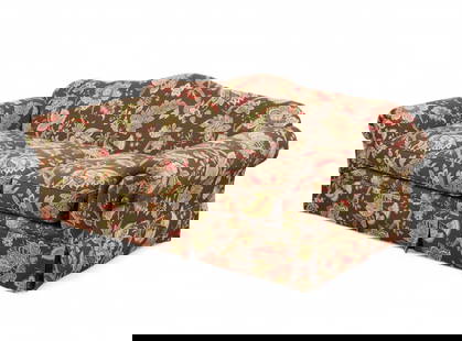 A floral upholstered three-seat sofa: A floral upholstered three-seat sofaThree-cushion sofa with rolled arms and full skirt, upholstered in multicolor floral fabric on a chocolate brown ground.height 34 in. (86.4 cm); width 85 in. (215.9