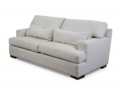 An off-white contemporary two-cushion sofa: An off-white contemporary two-cushion sofaOf modern box-form design with square track arms and loose seat and back cushions, upholstered in textured natural linen-blend fabric. Raised on dark wood blo