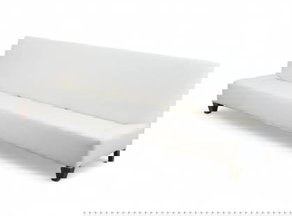 A contemporary upholstered banquette: A contemporary upholstered banquetteOf elongated armless form with a tall tight back and firm upholstered seat, covered in off-white fabric and raised on tapering square wood legs.height 32in (81cm);