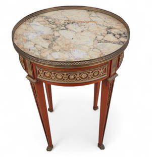 A Louis XVI style gilt bronze mounted mahogany gueridon, late 19th/early 20th century: A Louis XVI style gilt bronze mounted mahogany gueridonlate 19th/early 20th centuryWith inset marble top.height 41 3/4in (106cm); diameter 24in (61cm)