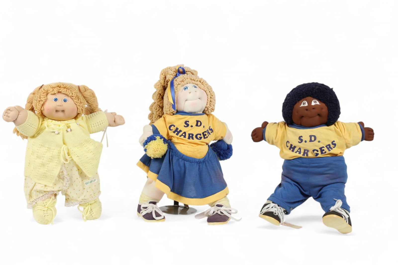 Three Cabbage Patch kids, circa 1983 & 1985: Three Cabbage Patch kids circa 1983 & 1985 Comprising a pair of young boy and girl San Diego Chargers cheerleaders, signed in ink to reverse Janet T. Waters, numbered and dated 28/1000 '83 and 87/1000