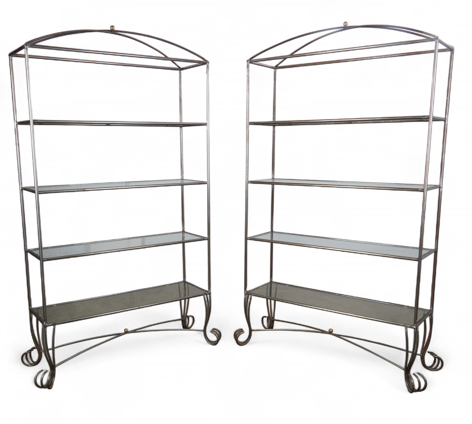 A pair of iron etageres with four glass shelves: A pair of iron etageres with four glass shelves height 89 x width 50 x depth 16 in. (226.1 x 127 x 40.6 cm.)