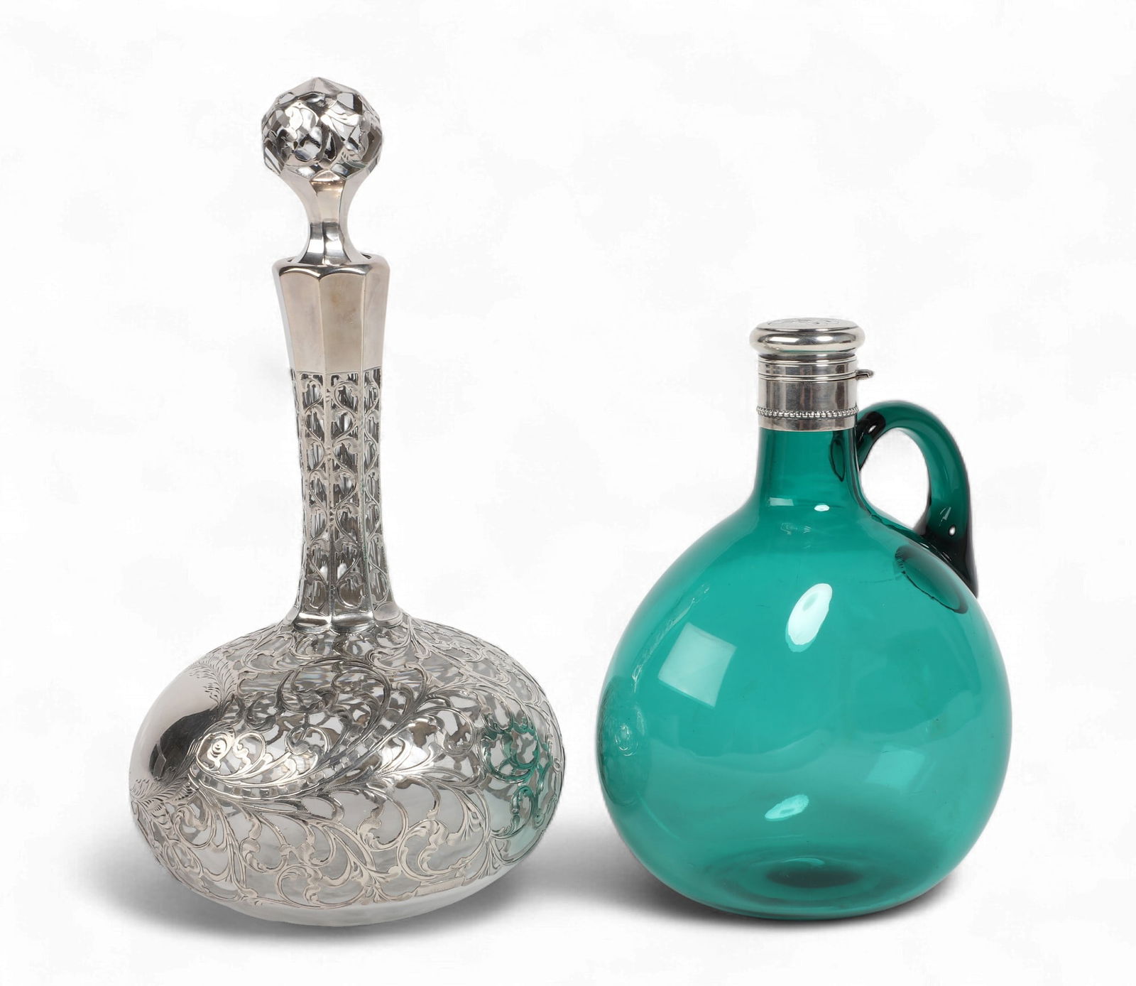 Two American sterling silver and glass decanters, Gorham and another maker: Two American sterling silver and glass decantersGorham and another makerlate 19th/early 20th centuryComprising a silver deposit bottle decanter and a Gorham silver mounted emerald glass jug, monogram: