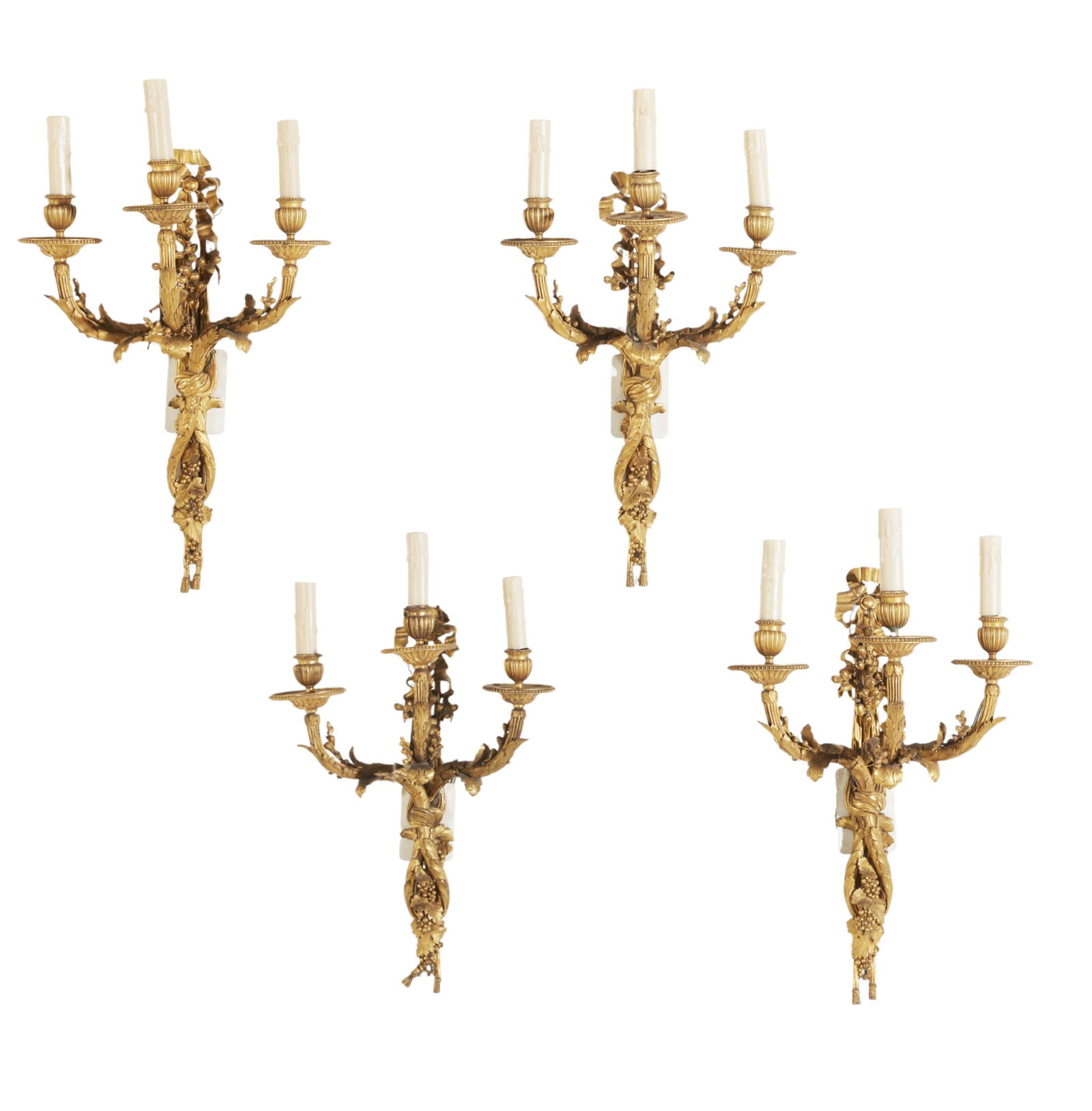 A set of four of Louis XVI style gilt bronze three branch wall lights, late 19th century: A set of four of Louis XVI style gilt bronze three branch wall lightslate 19th centuryheight 24in (61cm); width 16in (41cm); depth 9 1/2in (24cm) Provenance:With Gerald Tomlin Antiques, Dallas, TX,