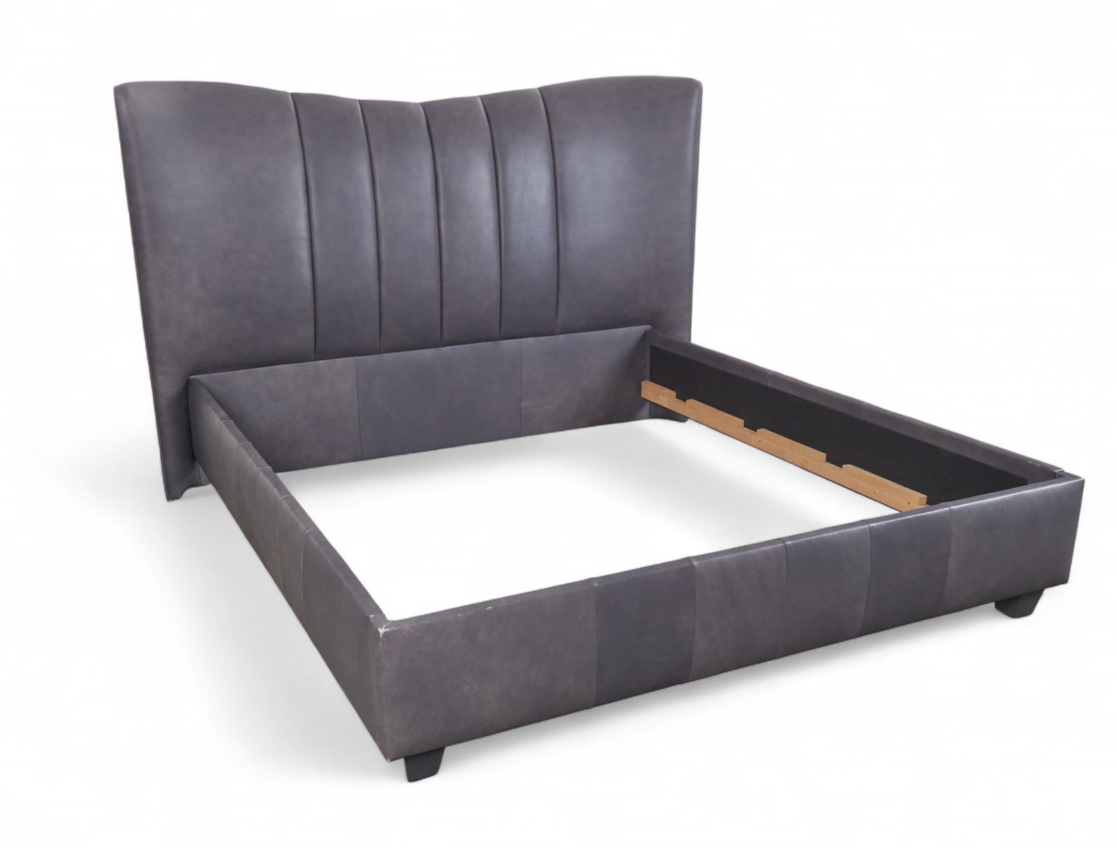 A leather upholstered king size bed: A leather upholstered king size bed including headboard, side rails and footboard Headboard: 57 x 89 in. (144.8 x 226.1 cm.)