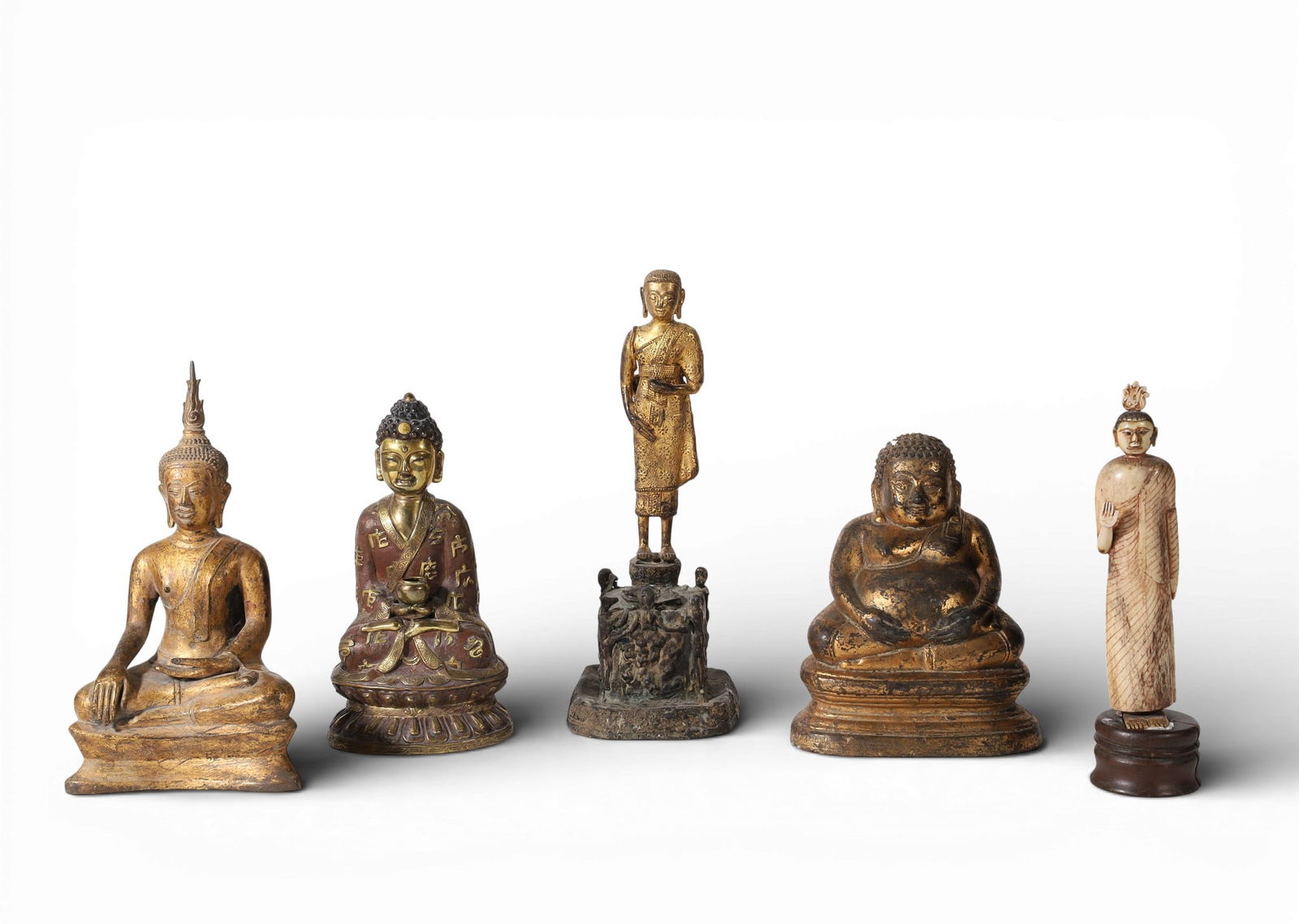 Five Asian bronze, metalware and bone models of Buddha and Budai: Five Asian bronze, metalware and bone models of Buddha and Budailargest height 10 3/4in (27cm); width 4in ( 4 1/2 Provenance:Property from the Preiser Collection.