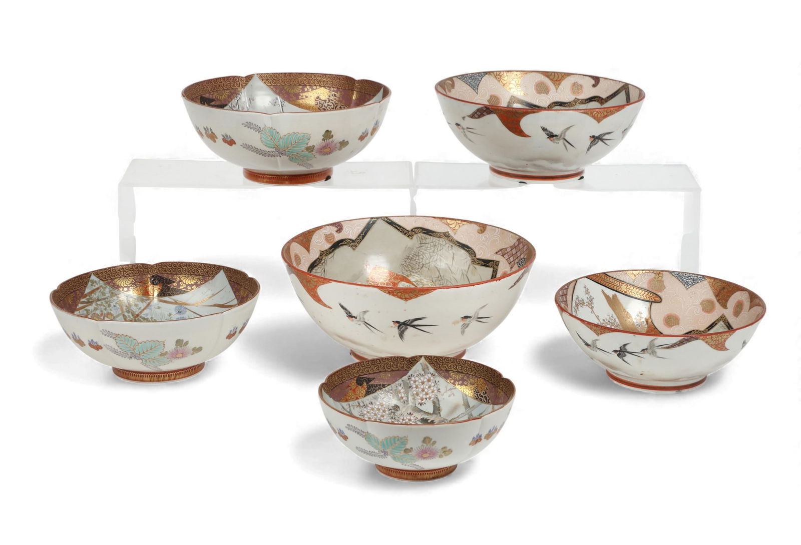 A group of six Japanese parcel gilt enameled Kutani bowls: A group of six Japanese parcel gilt enameled Kutani bowlsComprising a set of three graduated bowls depicting birds and fowl and the other set of three graduated bowls depicting samurais, each with red