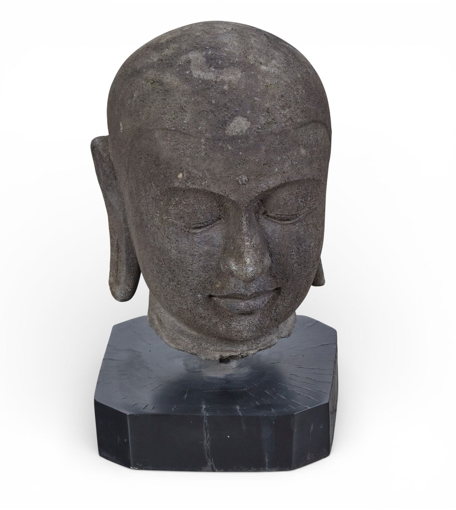 A carved stone Buddha head on stand: A carved stone Buddha head on standheight 20 x width 12 x depth 11 in. (50.8 x 30.5 x 27.9 cm.)