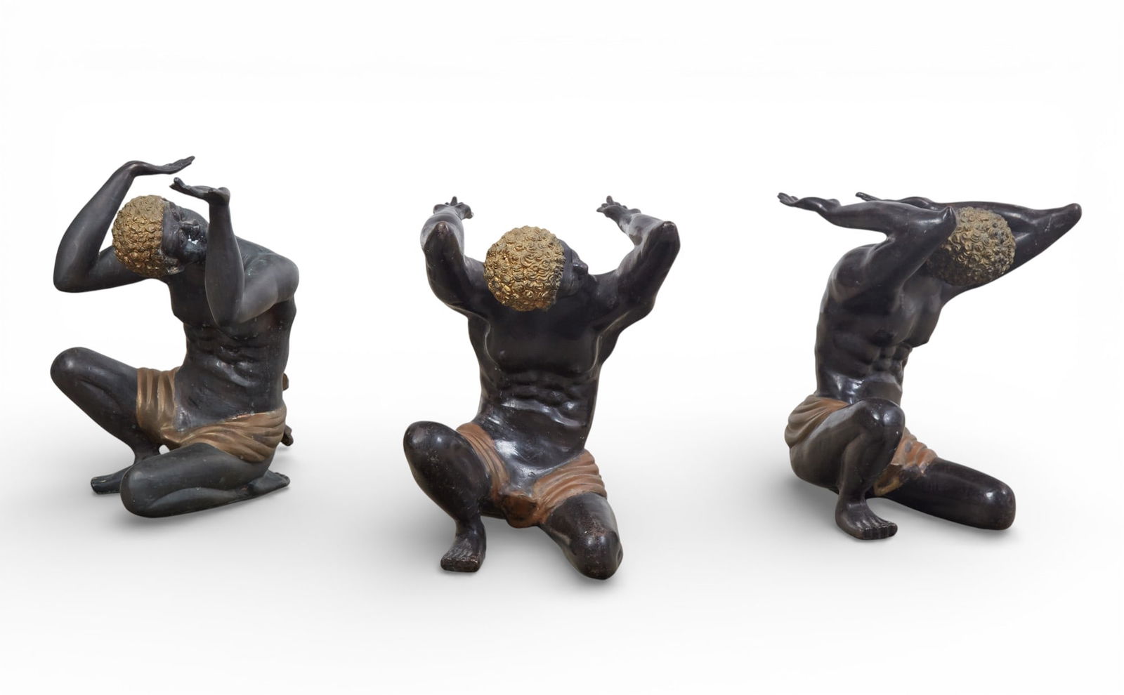 A group of three bronze squatting figures: A group of three bronze squatting figuresheight 21 x width 18 1/2 in. (53.3 x 47 cm.)