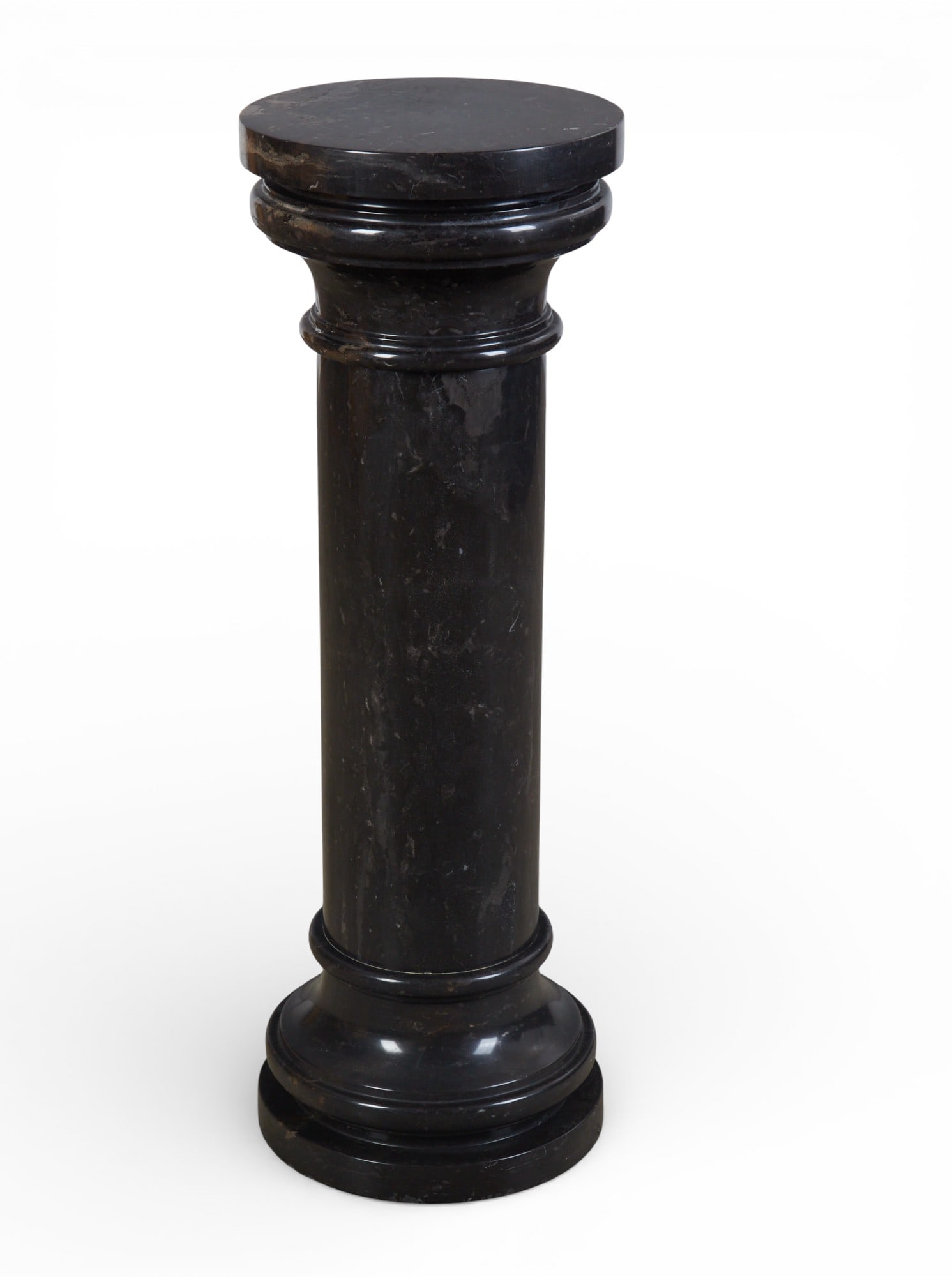 A black marble pedestal, modern: A black marble pedestal modern height 38in (95cm); diameter 13in (32.5cm) Provenance: Property from a Private Collection, Beverly Hills, California.