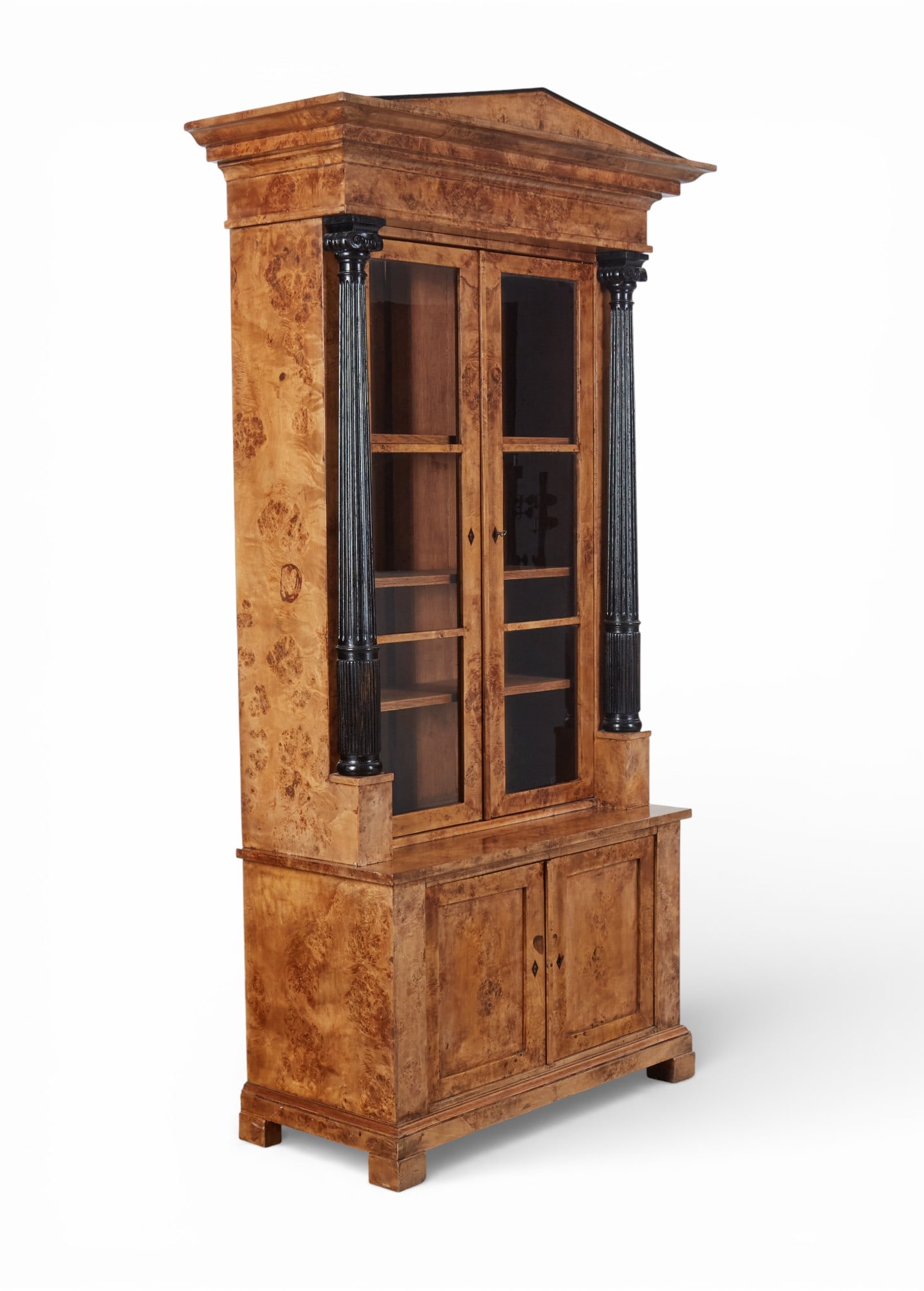 A Biedermeier display cabinet with ebonized columns .: A Biedermeier display cabinet with ebonized columns . height 96 x width 43 x depth 20 in. (243.8 x 109.2 x 50.8 cm.)