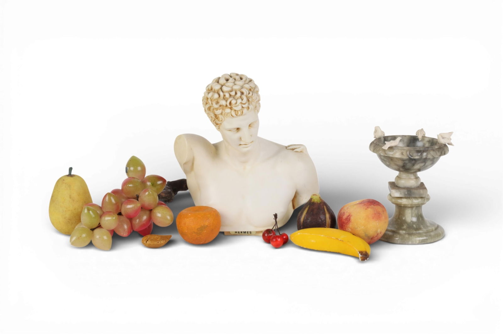 An assembled ten piece group of marble fruit, a tazza and a resin Classical bust of Hermes of: An assembled ten piece group of marble fruit, a tazza and a resin Classical bust of Hermes of Praxiteles bust height overall 12in (30.5cm); width 9in (23cm); depth 6in (15cm)