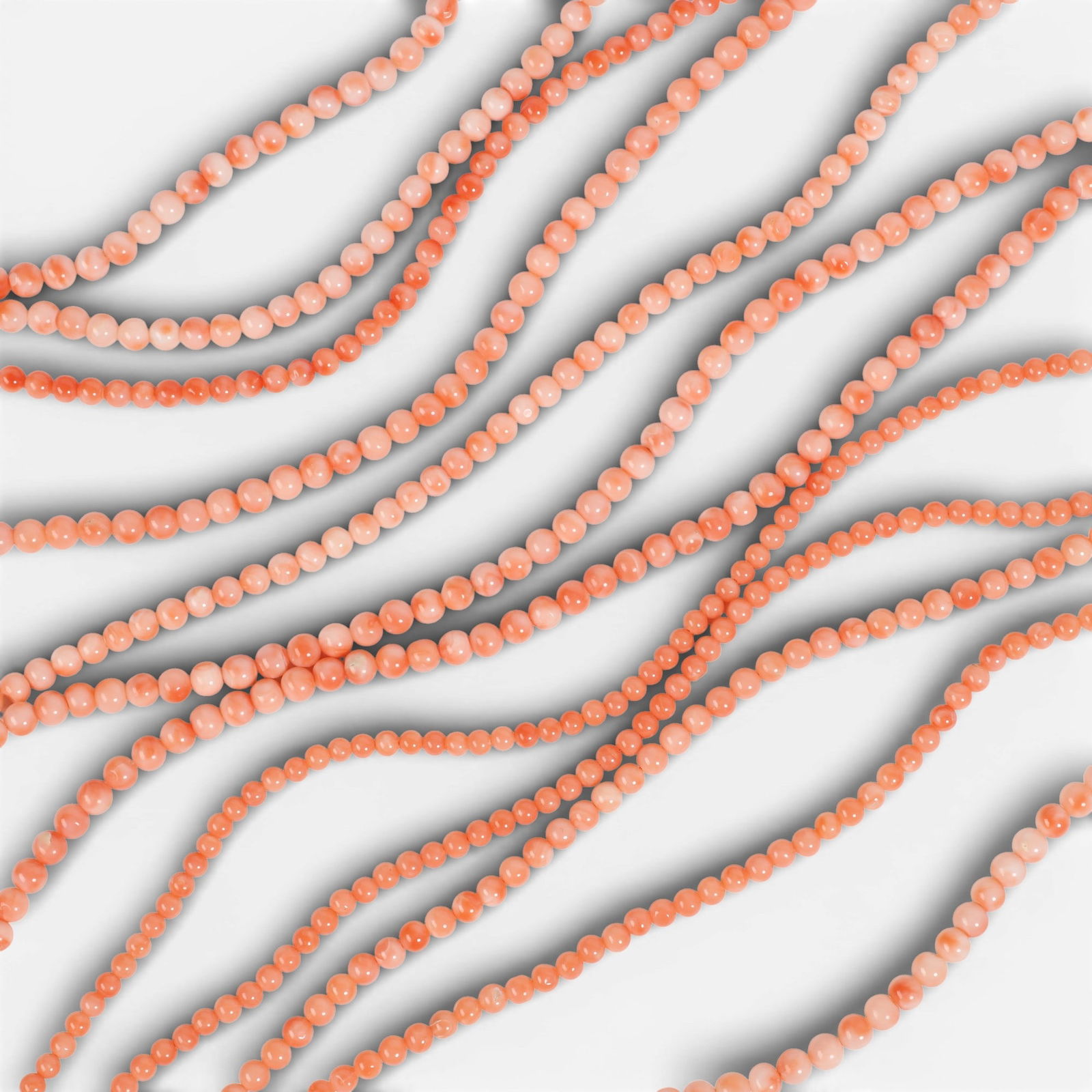 A large group of coral bead strands.: A large group of coral bead strands.