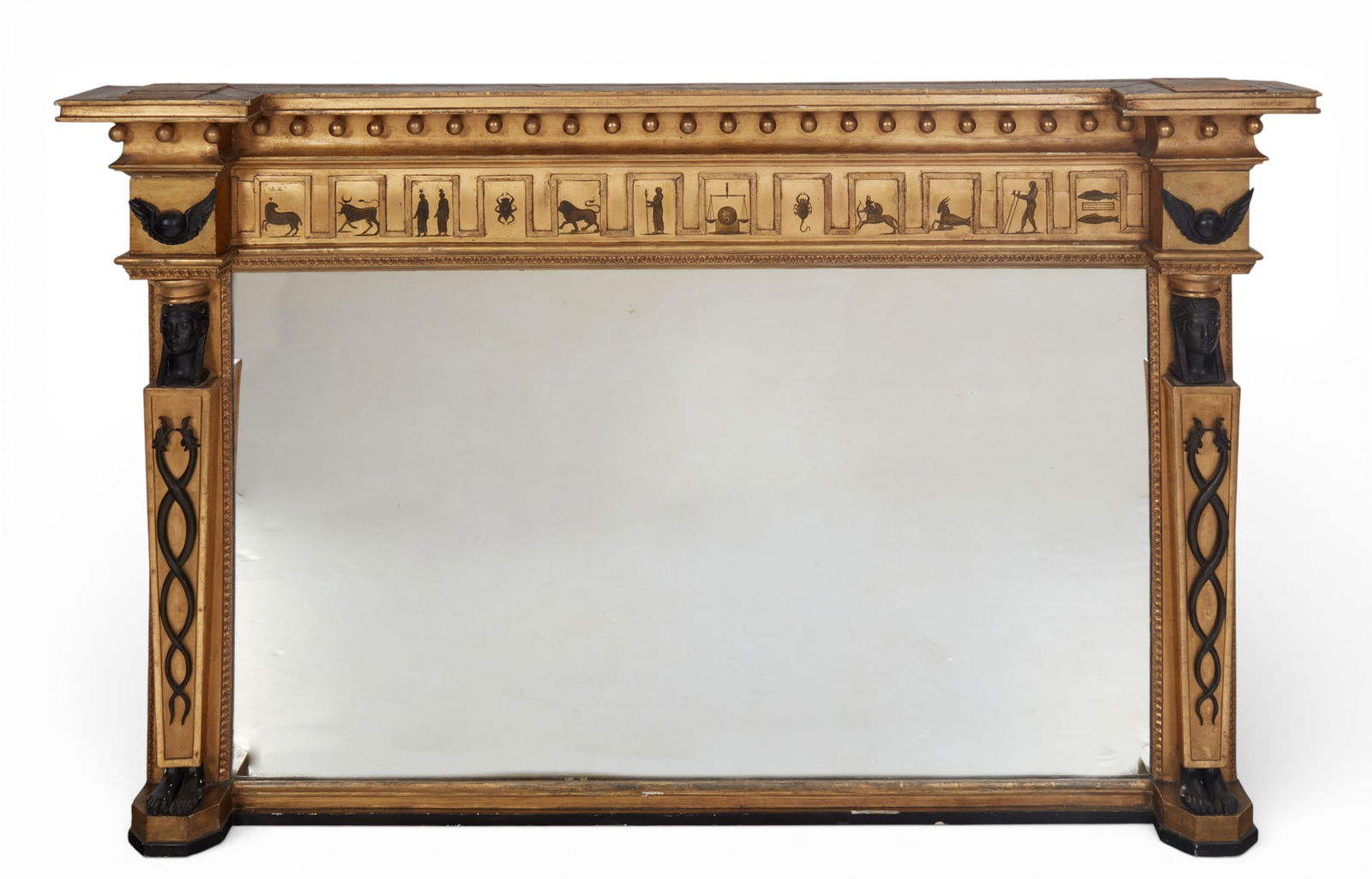 An Irish Regency ebonized & giltwood Egyptian Revival overmantel mirror, Joshua Kearney, Dublin: An Irish Regency parcel ebonized giltwood Egyptian Revival overmantel mirrorJoshua Kearney, Dublinfirst quarter 19th centuryWith manufacturer's label to reverse.height 44in (112cm); width 69in (175cm)